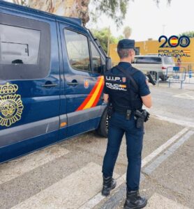 Agente de la Policía Nacional en Melilla junto a una furgoneta policial