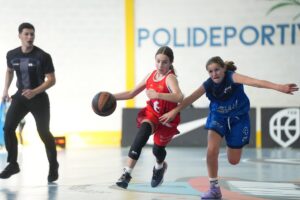 Jugadoras de minibasket compitiendo en un partido en el polideportivo.