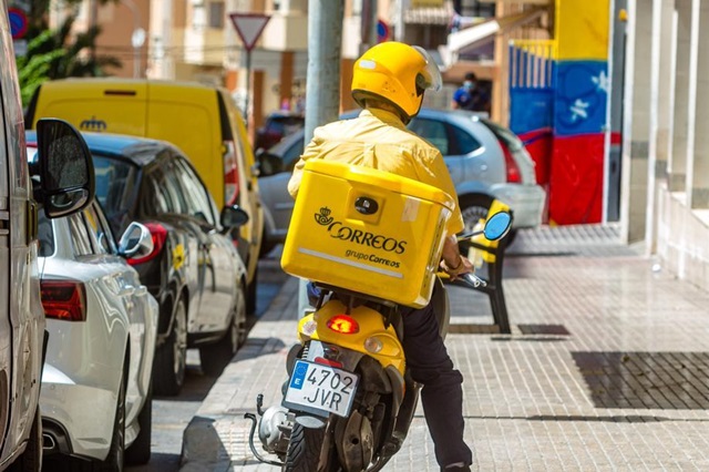 Repartidor de Correos en motocicleta en una calle urbana