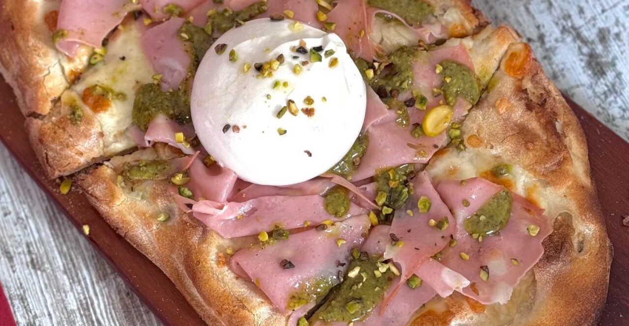 Pizza artesanal con jamón, pesto y queso en el restaurante Volterra.