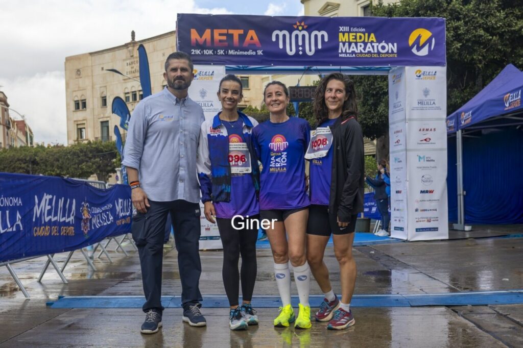 Participantes en la XIII Media Maratón de Melilla con el arco de meta de fondo