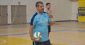 Entrenador Salim Abdelkader sosteniendo un balón de voleibol en el gimnasio