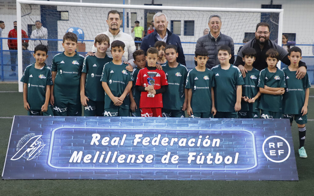 Equipo de fútbol CD Buen Consejo posando con trofeo en el campo