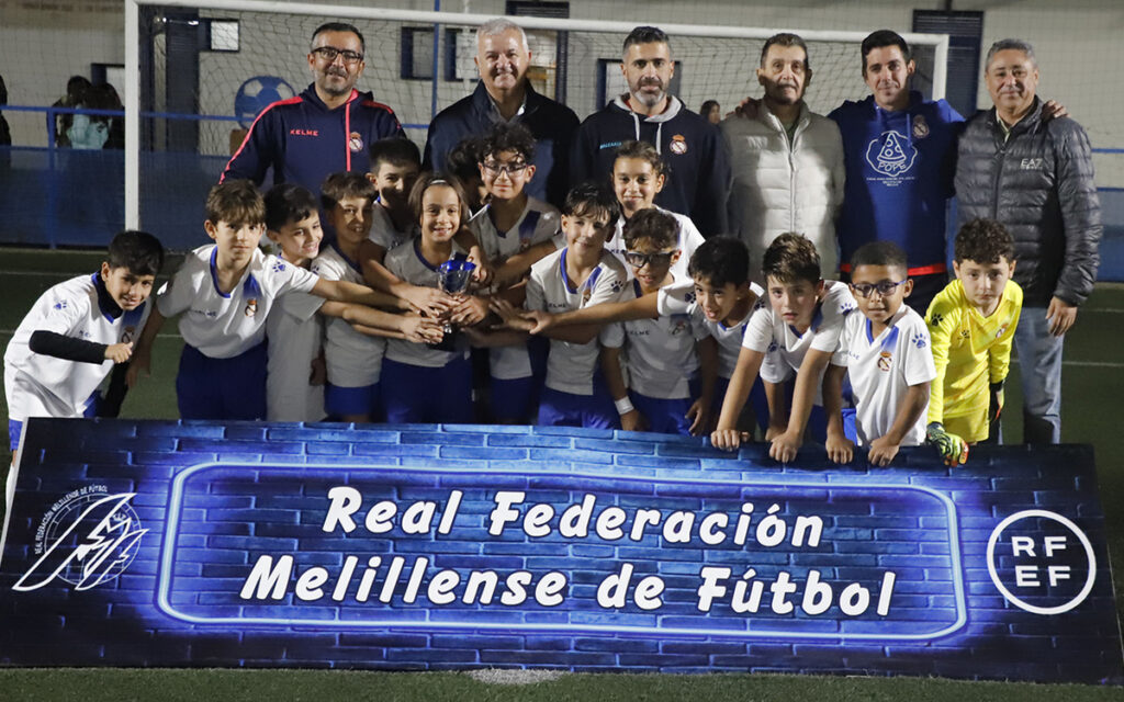 Equipo de fútbol Peña Santillana A posando con trofeo en el campo