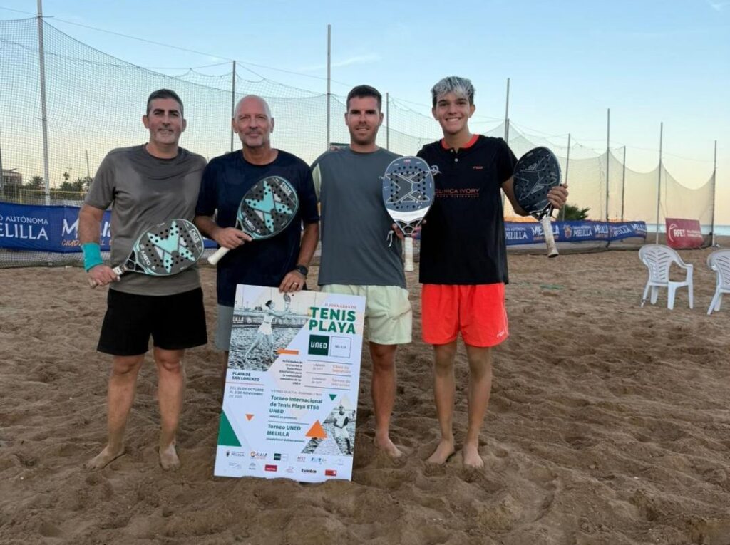 Cuatro jugadores de tenis playa posando con raquetas en la playa