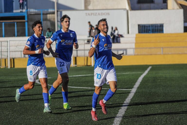 Jugadores de la U.D. Melilla B celebrando un gol en el campo.