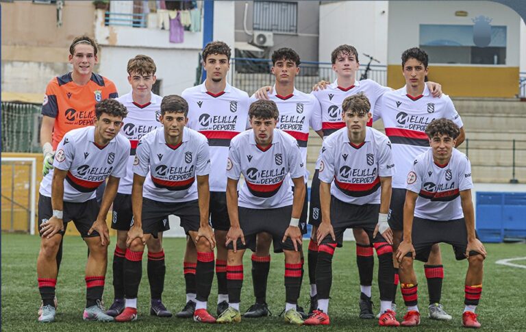 Equipo juvenil de la U.D. Melilla posando en el campo de fútbol.