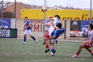 Jugadores de fútbol en acción durante un partido juvenil en Armilla