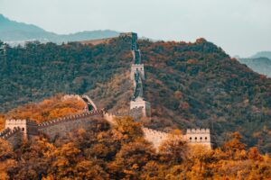 Gran Muralla China rodeada de montañas y árboles en otoño