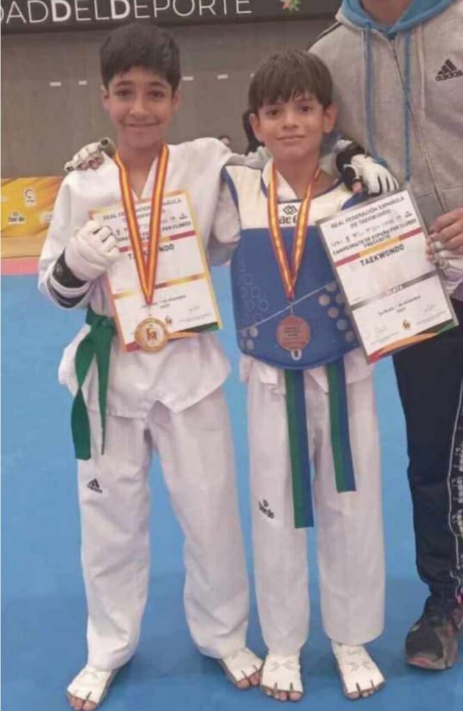 Adam y compañero con medallas en campeonato de taekwondo