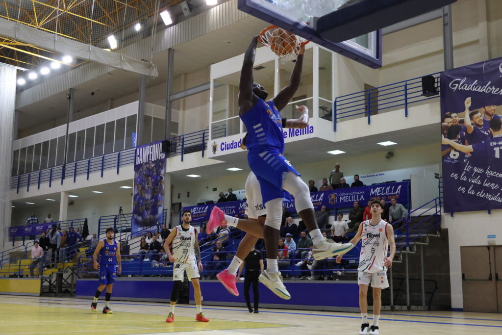 Jugador del Club Melilla Baloncesto realizando un mate en el partido