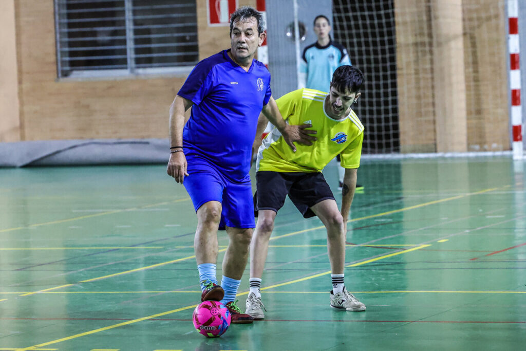 Jugadores compitiendo en un partido de fútbol sala navideño