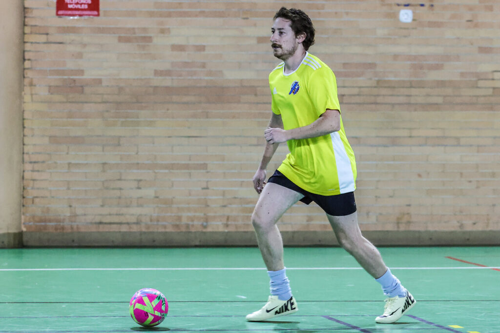 Jugador corriendo con balón en partido de Navidad entre APDM y RFMF