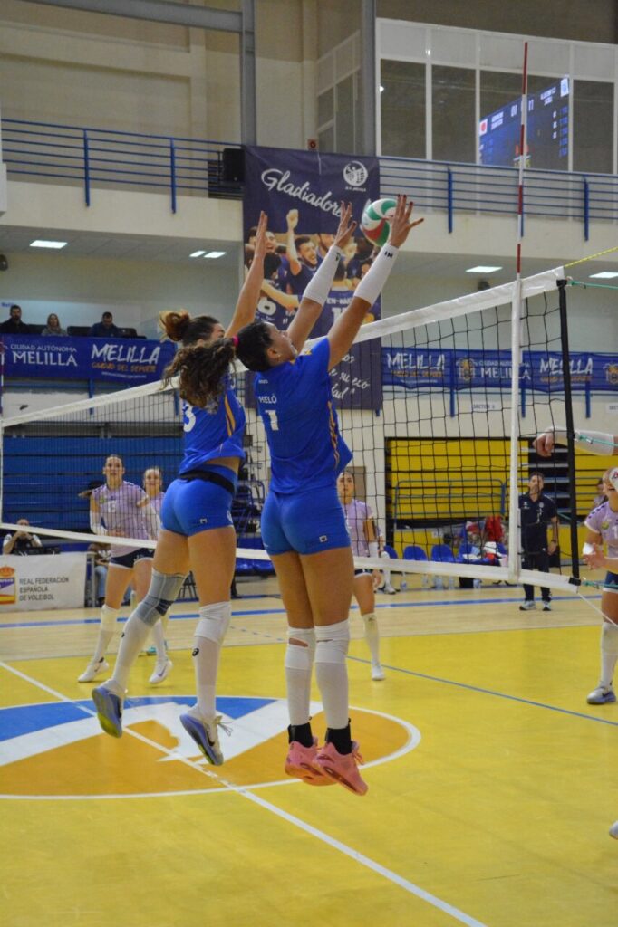 Jugadoras del Club Voleibol Melilla saltando para bloquear un remate.