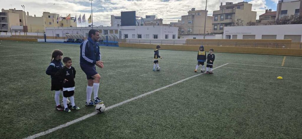 Niños en entrenamiento de fútbol en el campo bajo la lluvia