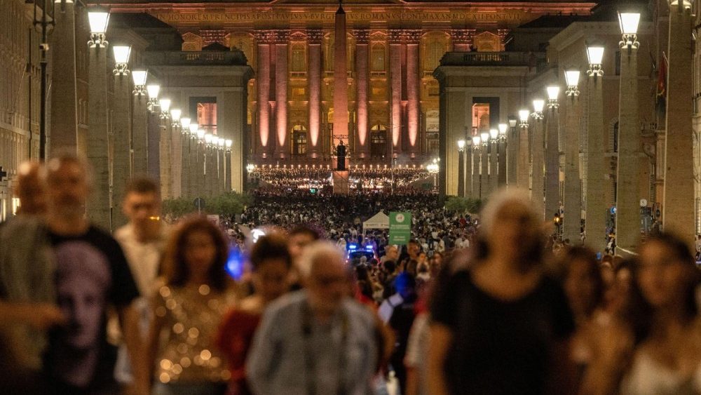 Multitud asistiendo a un concierto en un ambiente festivo y espiritual.