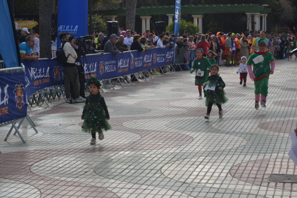 Niños corriendo en la carrera San Silvestre de Melilla con disfraces festivos
