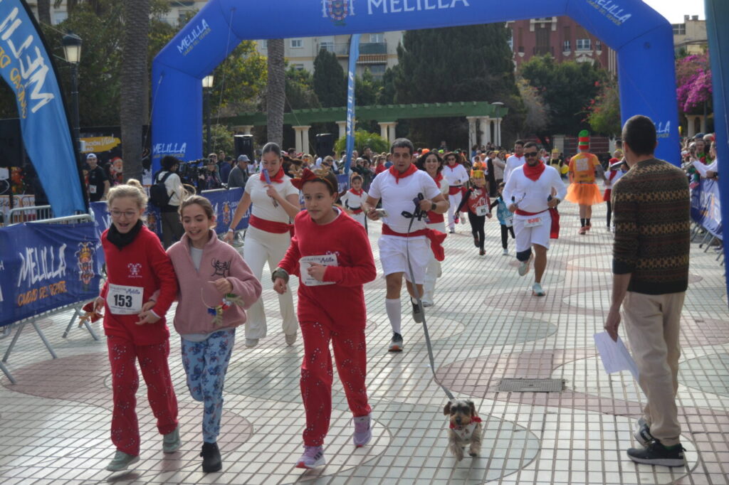 Participantes corriendo en la San Silvestre de Melilla con disfraces festivos