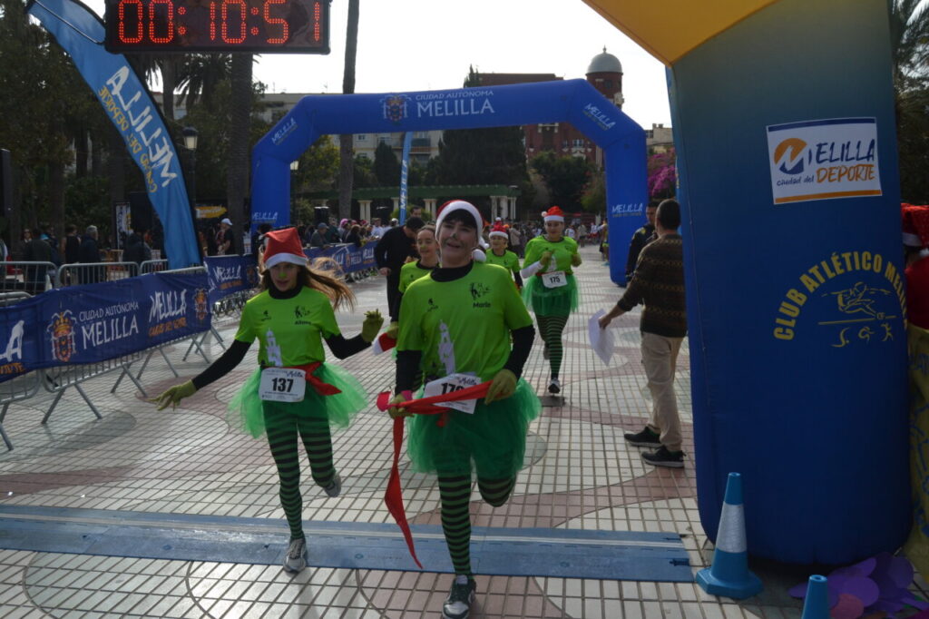Participantes corriendo en la San Silvestre de Melilla con disfraces navideños