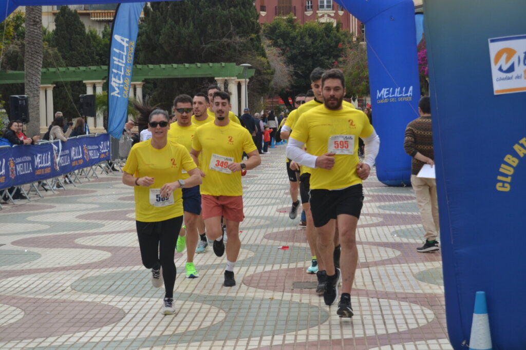 Corredores participando en la San Silvestre de Melilla con camisetas amarillas