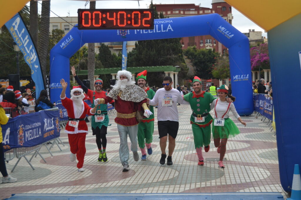 Atletas disfrazados cruzando la meta en la San Silvestre de Melilla