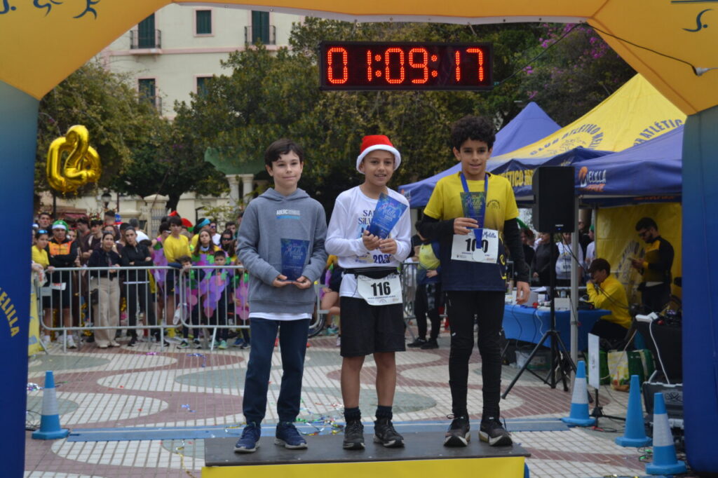 Tres niños en el podio de la San Silvestre de Melilla con trofeos