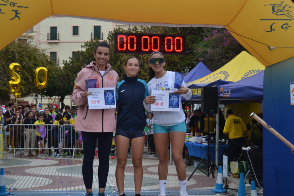 Tres mujeres sosteniendo trofeos en la San Silvestre de Melilla 2025