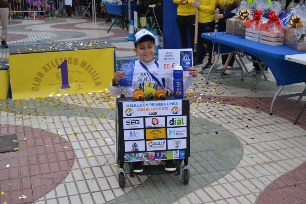 Niño sosteniendo premios en la carrera San Silvestre de Melilla 2025