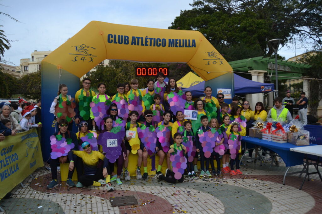 Grupo de participantes en la San Silvestre de Melilla con disfraces de uvas