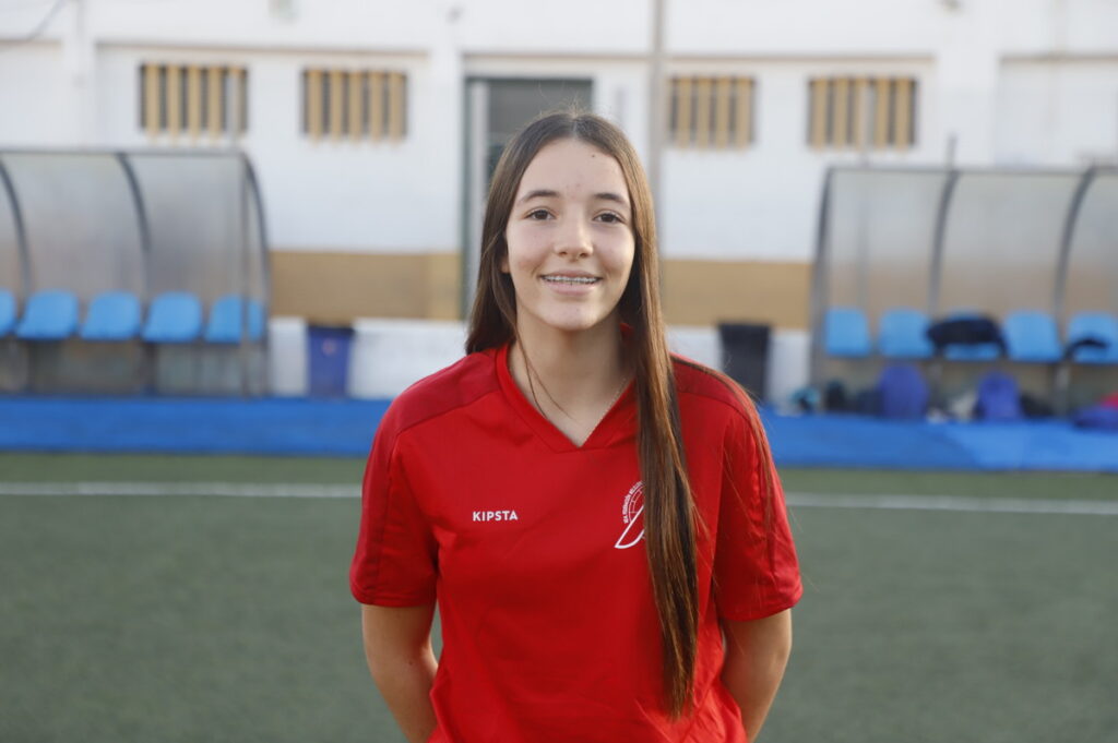 Jugadora del equipo Sub-14 de Melilla en uniforme rojo en el campo