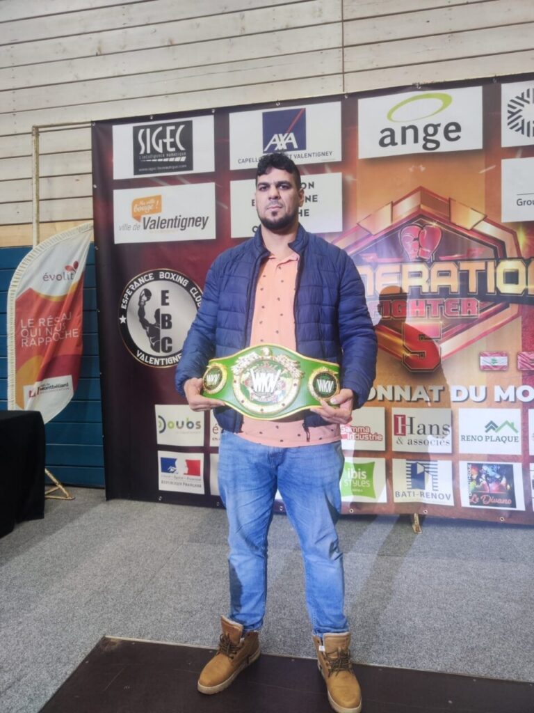 Deportista del Club Olympic Center Melilla sosteniendo un cinturón de campeón