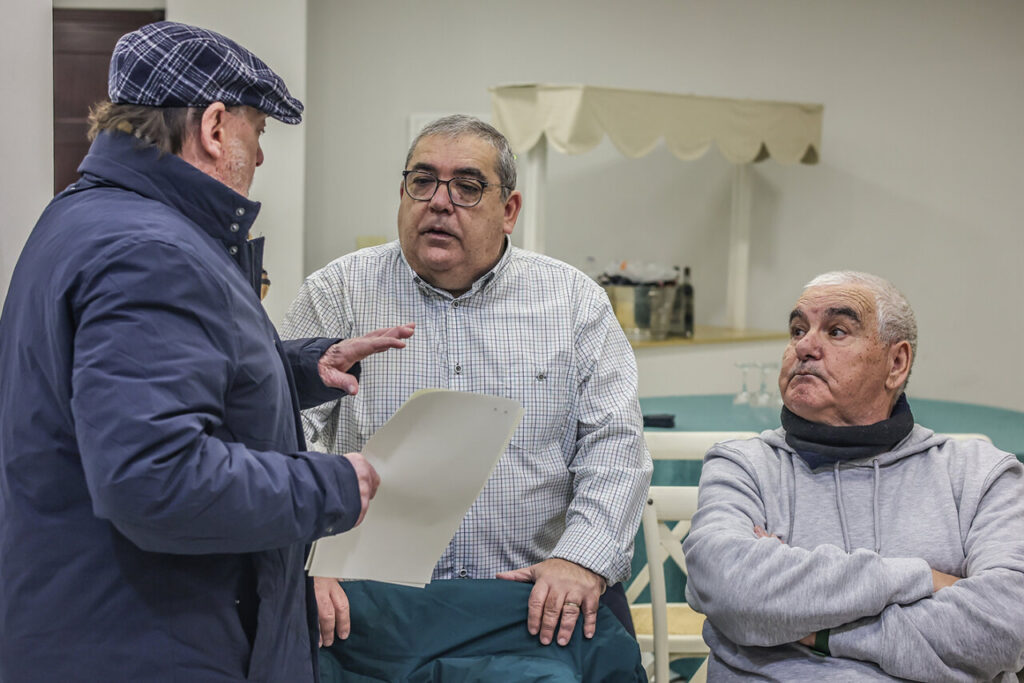 Tres hombres conversando en un encuentro de la APDM en Melilla