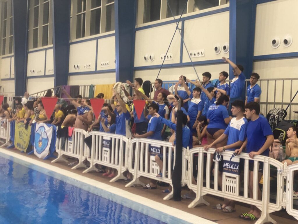 Aficionados animando en la piscina durante el trofeo de natación.