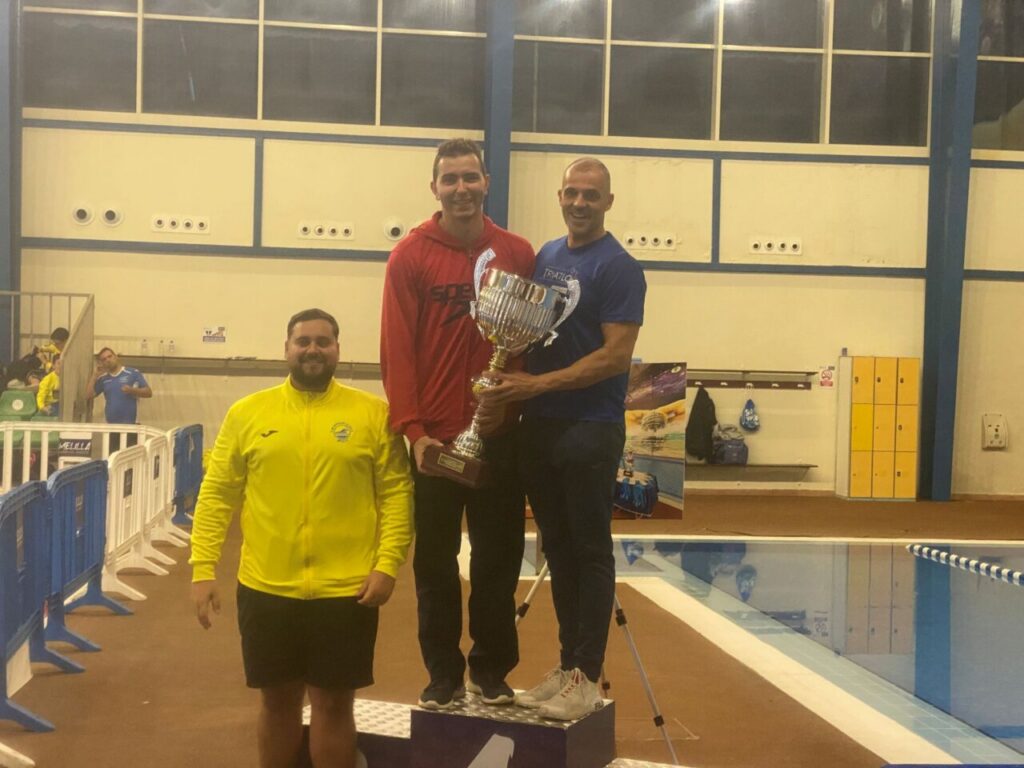 Ganadores del XIX Trofeo Ciudad de Melilla sosteniendo el trofeo en la piscina