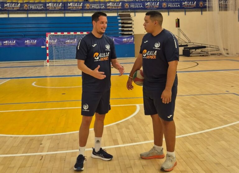 Entrenador Alberto Rodríguez conversando con un jugador en la cancha de voleibol