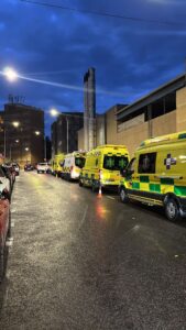 Ambulancias estacionadas en una calle bajo un cielo nublado