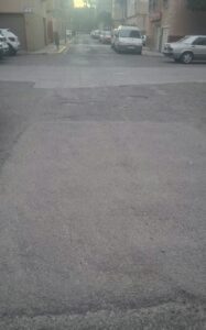 Calle deteriorada en el barrio del Hipódromo con baches visibles