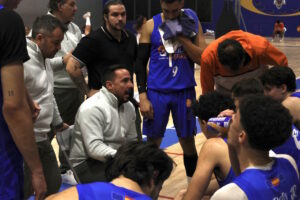 Entrenador hablando con el equipo de baloncesto durante un tiempo muerto