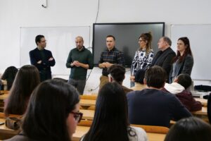 Grupo de expertos hablando frente a estudiantes en un aula