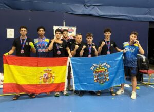 Equipo del Club Olympic Center Melilla con medallas y banderas en evento deportivo