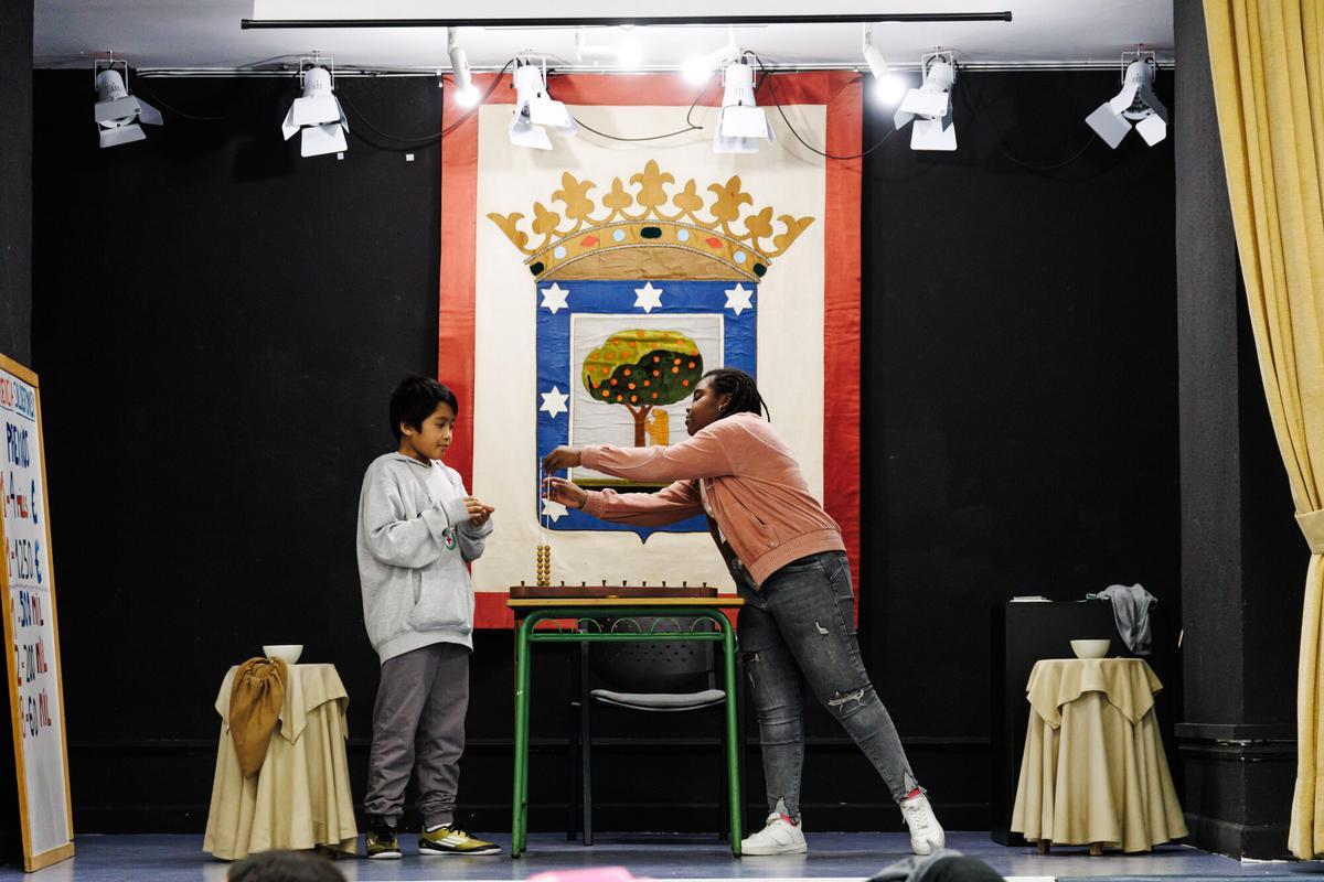 Niño y educadora ensayando para la Lotería de Navidad en el Colegio San Ildefonso