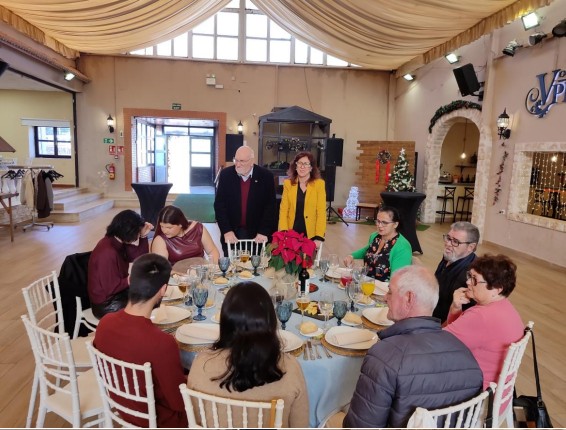 Grupo de personas disfrutando de una comida navideña en un salón decorado