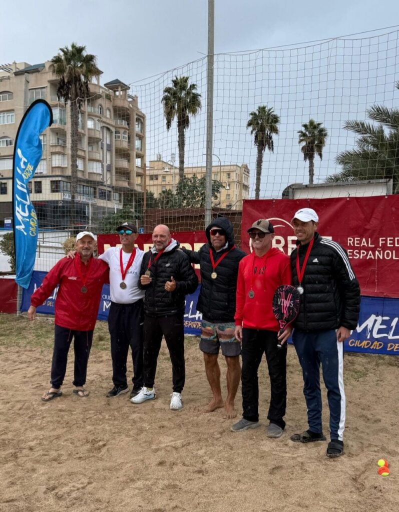 Grupo de jugadores veteranos con medallas en torneo de tenis playa