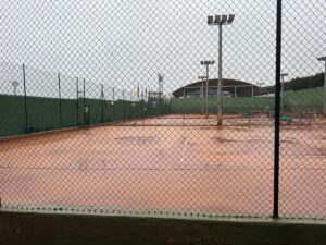 Pista de tenis mojada por la lluvia en un día nublado