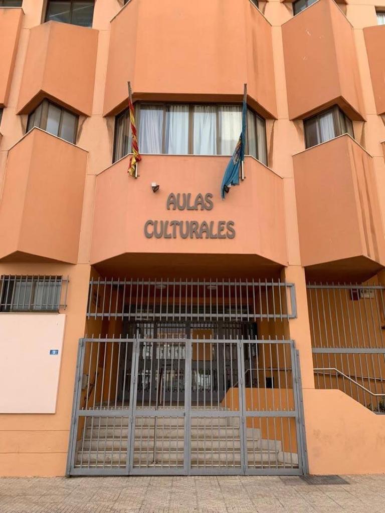 Fachada del edificio Aulas Culturales en Melilla con banderas