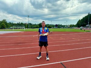 Edu Calderay sosteniendo medallas en una pista de atletismo