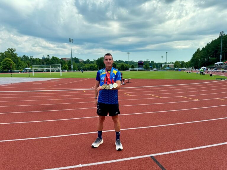 Edu Calderay sosteniendo medallas en una pista de atletismo