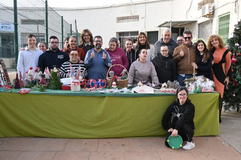 Grupo de personas en evento navideño mostrando artesanías