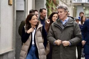 Alberto Núñez Feijóo conversando con una mujer en un evento político.