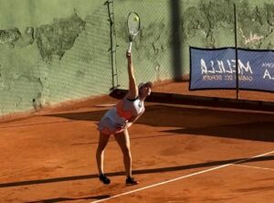 Jugadora de tenis realizando un saque en la pista de Melilla